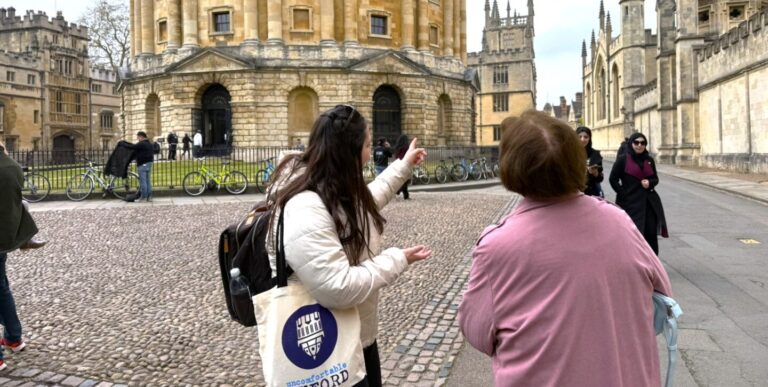 A tour guide points out the Radcliffe Camera to an onlooker on a cool day in Oxford