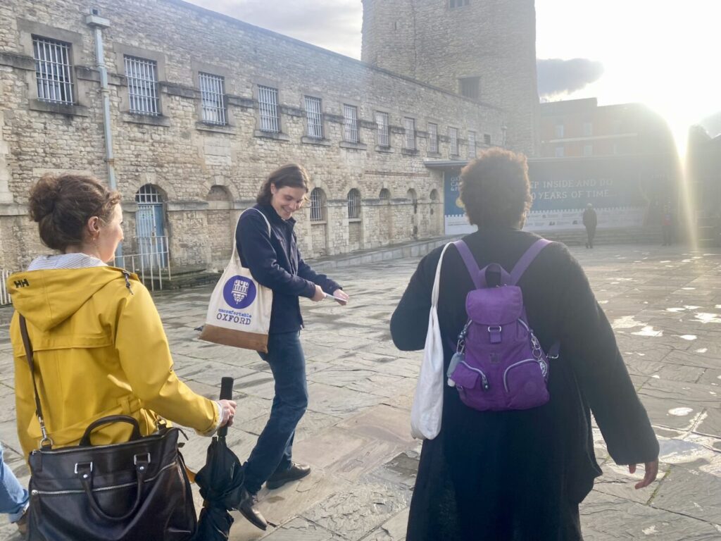An Uncomfortable Oxford guide leads a group on a walk through the medieval streets of Oxford.