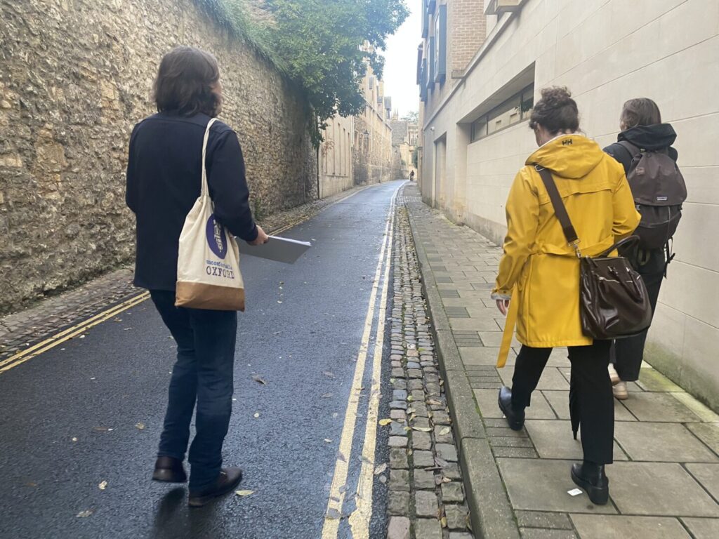 An Uncomfortable Oxford guide leads a group on a walk through the medieval streets of Oxford.