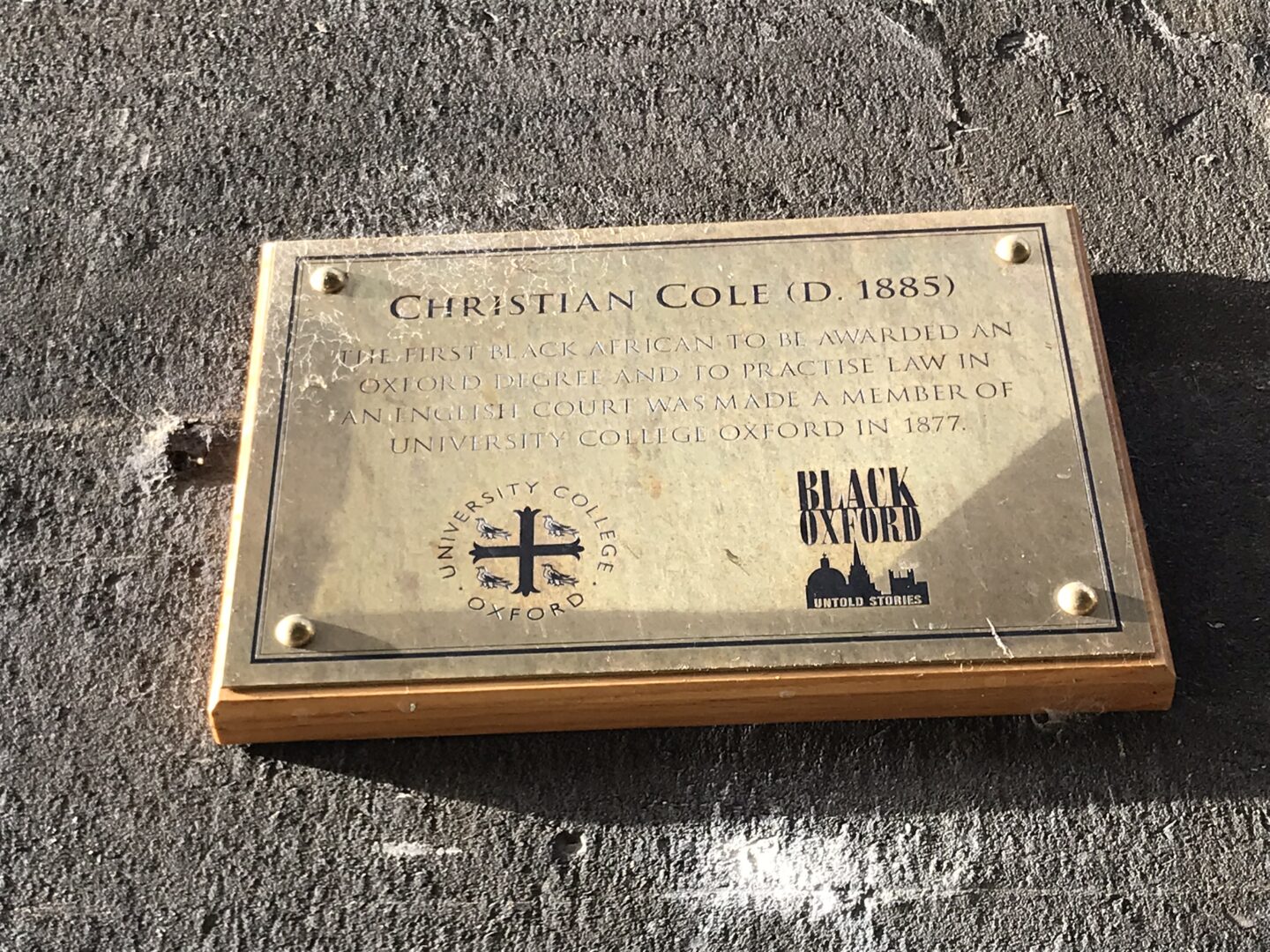 Rectangular golden memorial plaque on a wall.