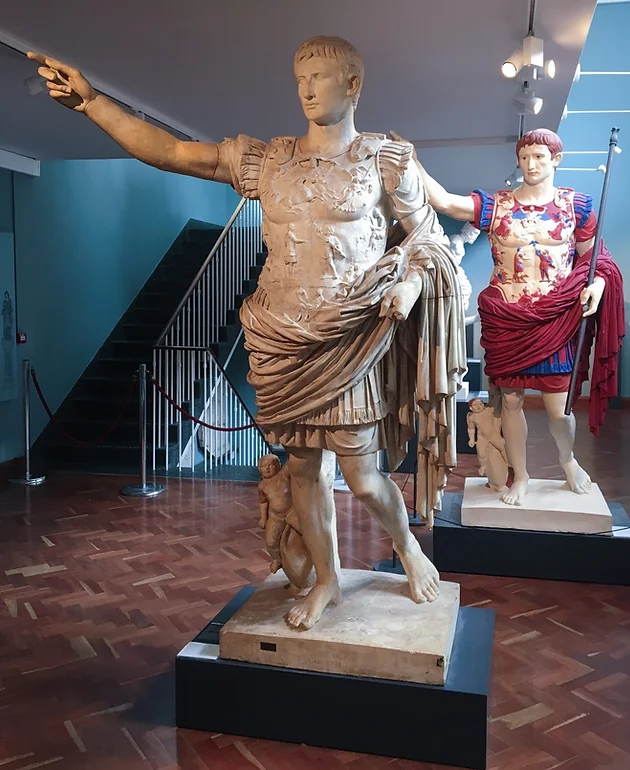 Plaster reconstructions of a roman sculpture in colours, showing original polychromy, situated next to its white marble counterpart in the Ashmolean Museum Cast Gallery.