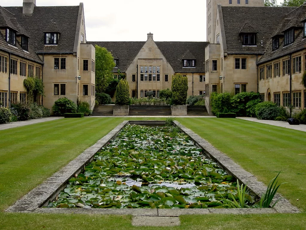 Pond with waterlilies in an internal garden surrounded by large buildings.