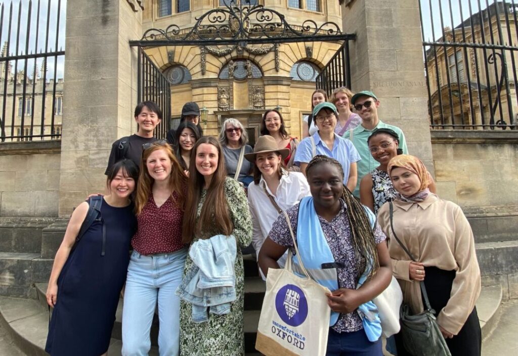 A group of people standing around a tour guide in front of a landmark